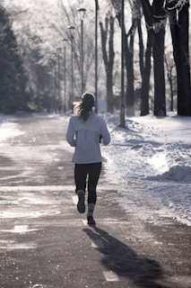 A woman running down a snow covered road