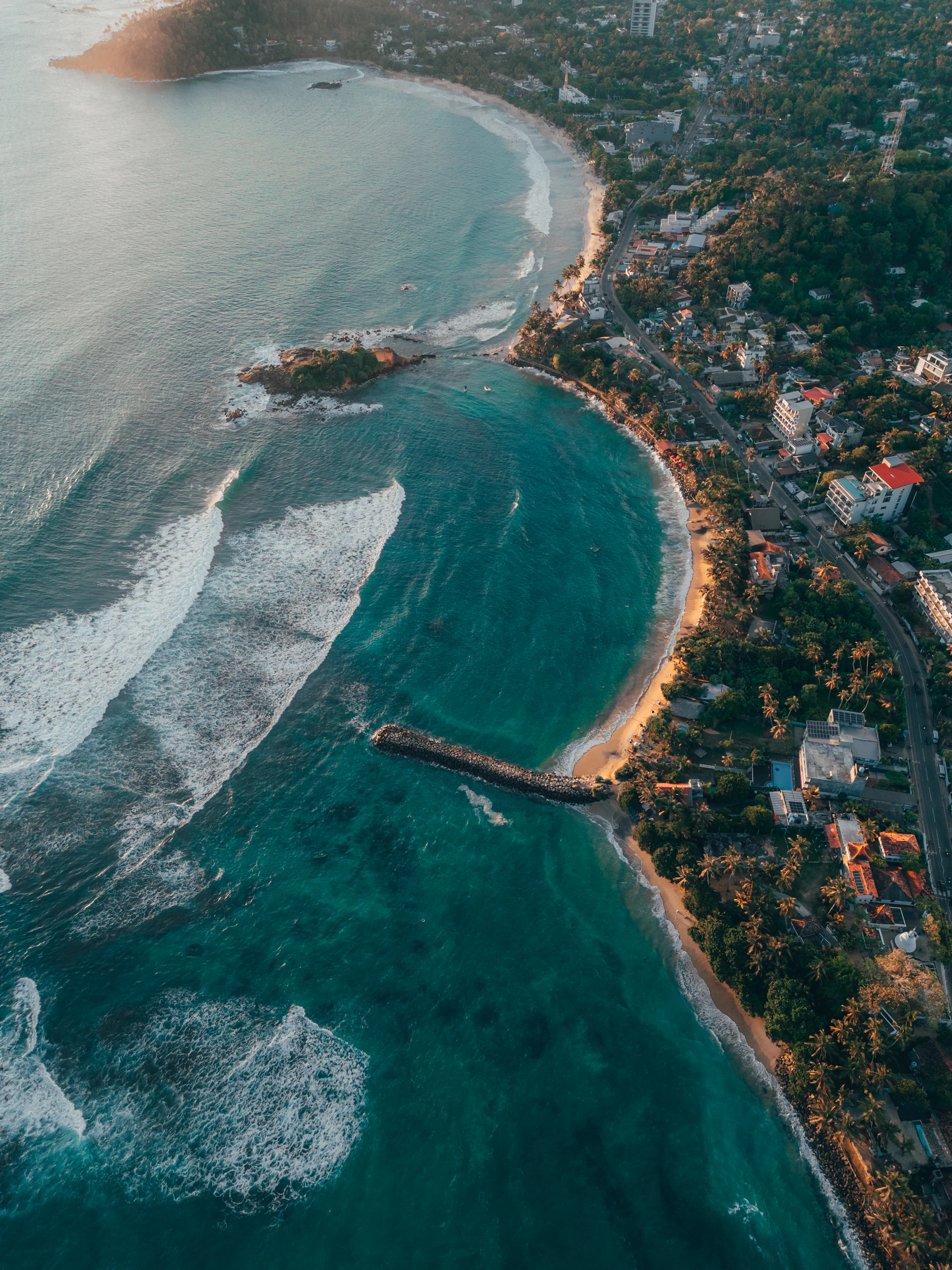 Aerial view of Mirissa bay with turquoise water and palm-lined beach