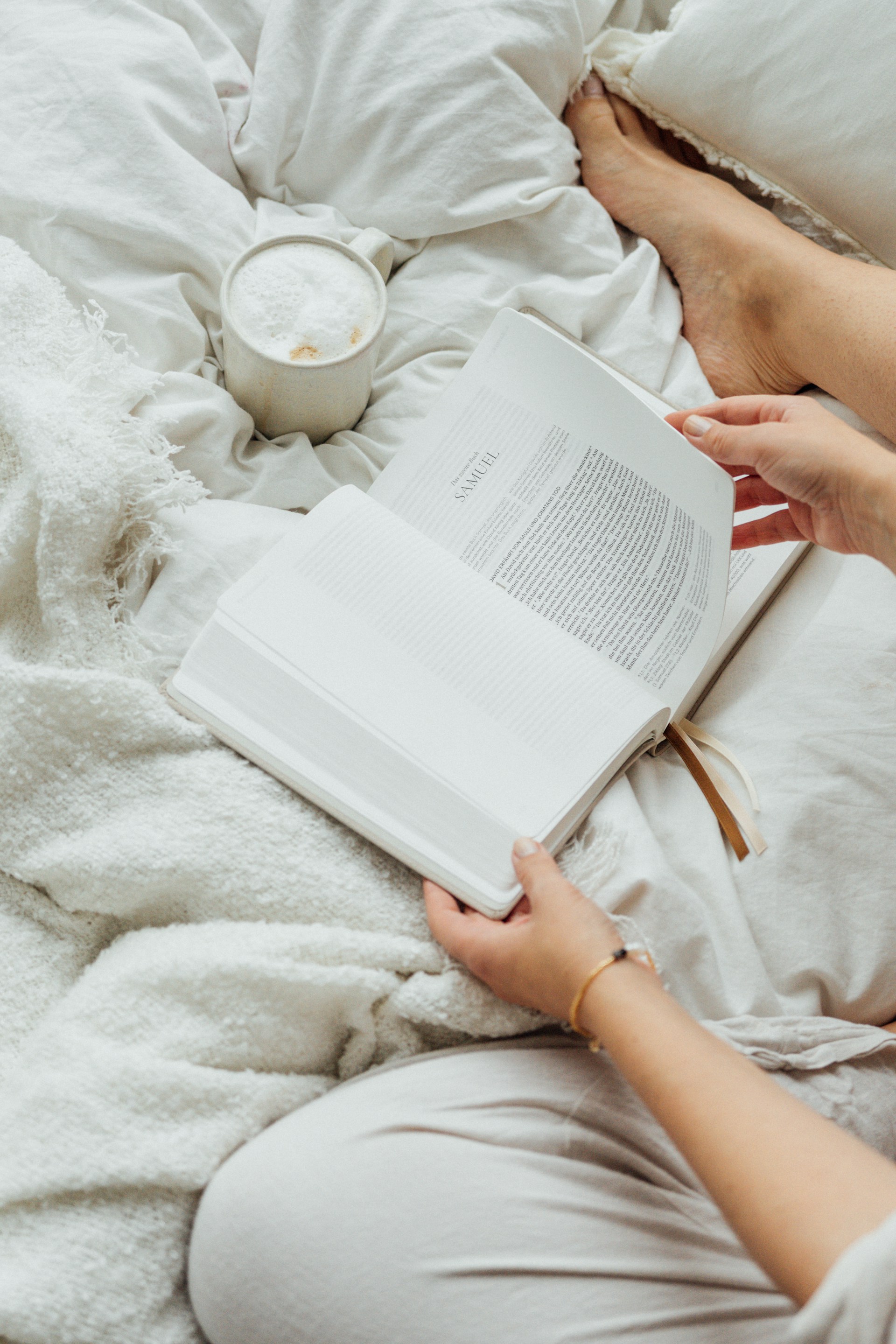 A woman laying in bed reading a book