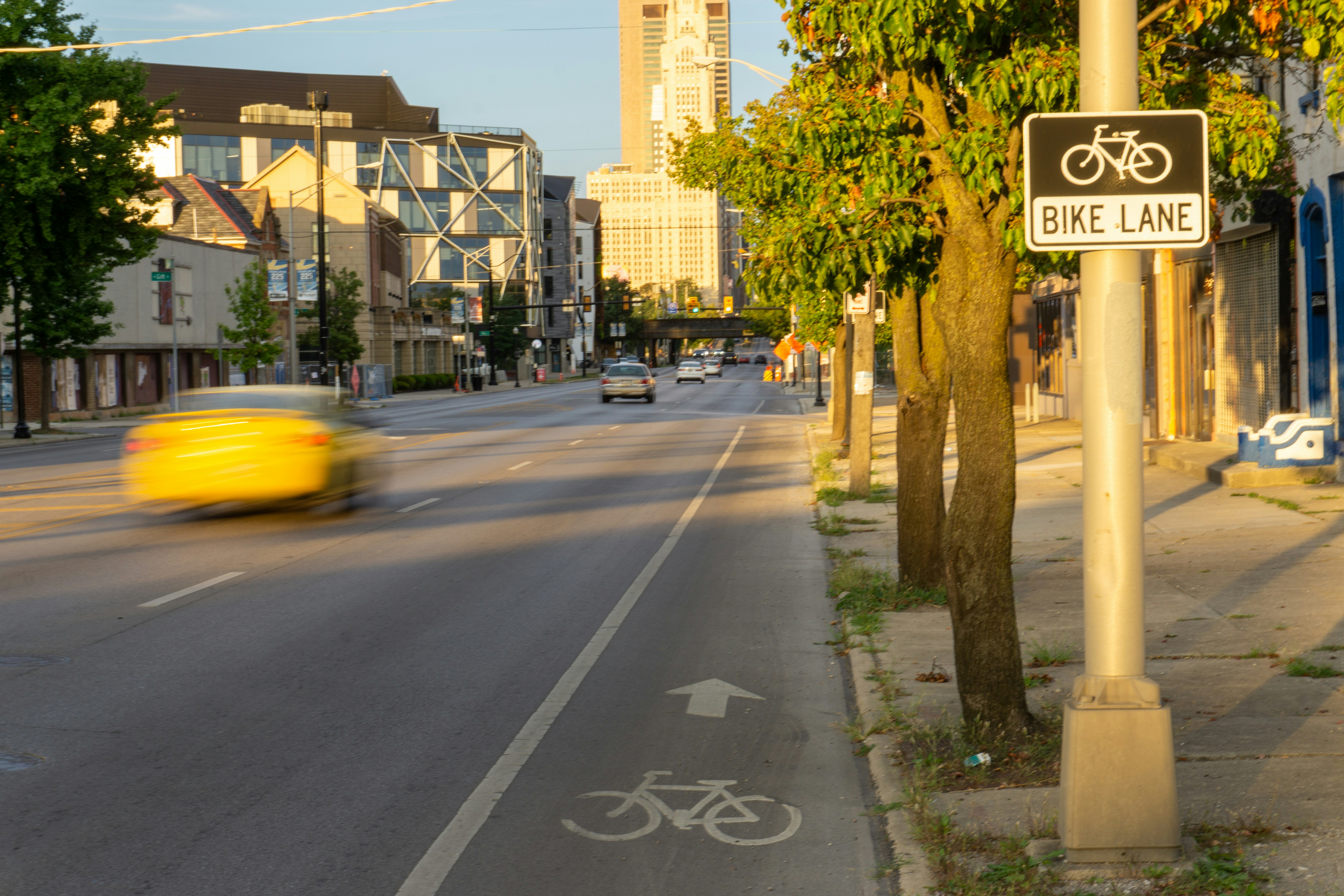 A city street with a bike lane and a clock tower in the background