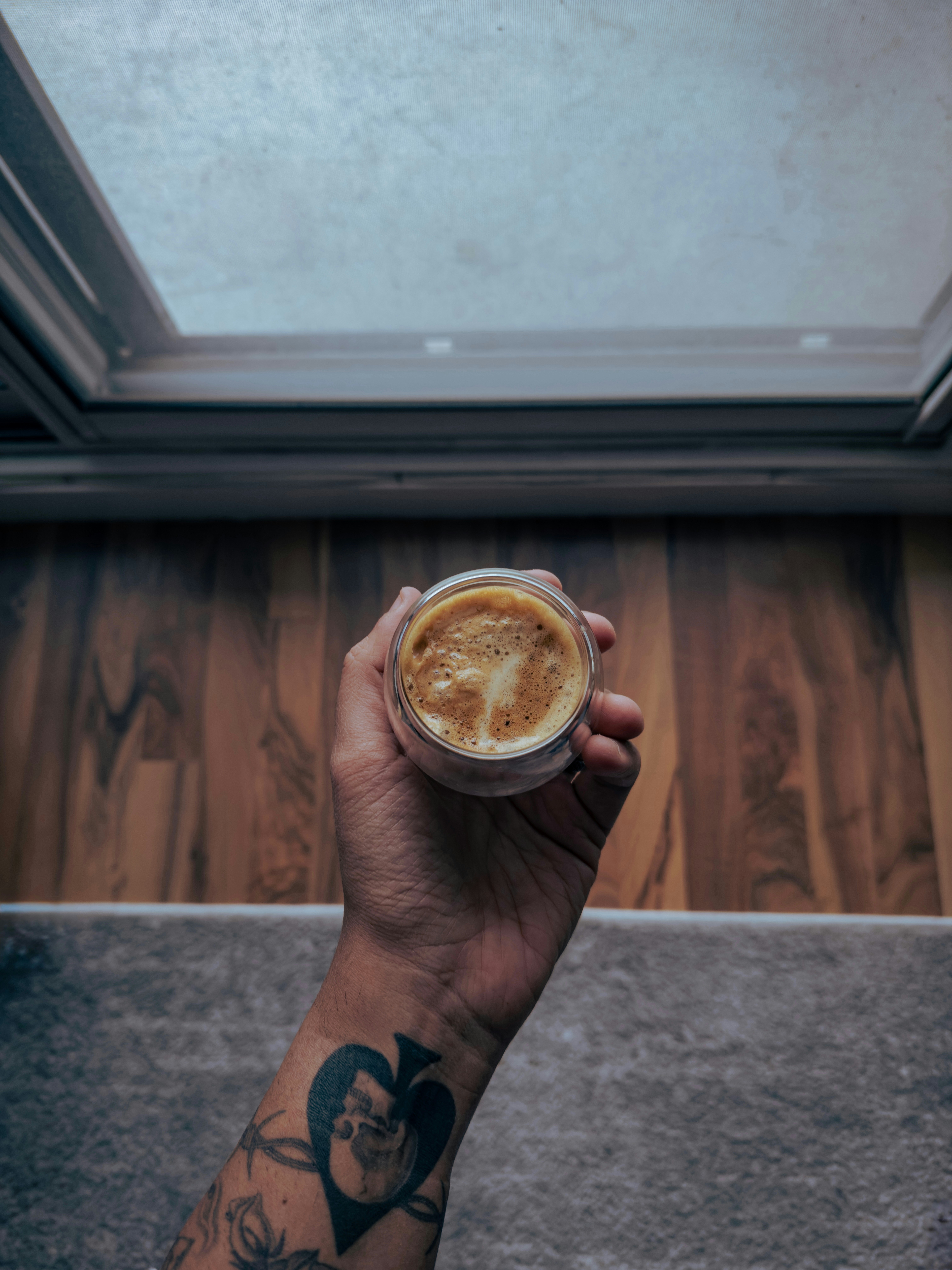 A person holding a cup of coffee in their hand