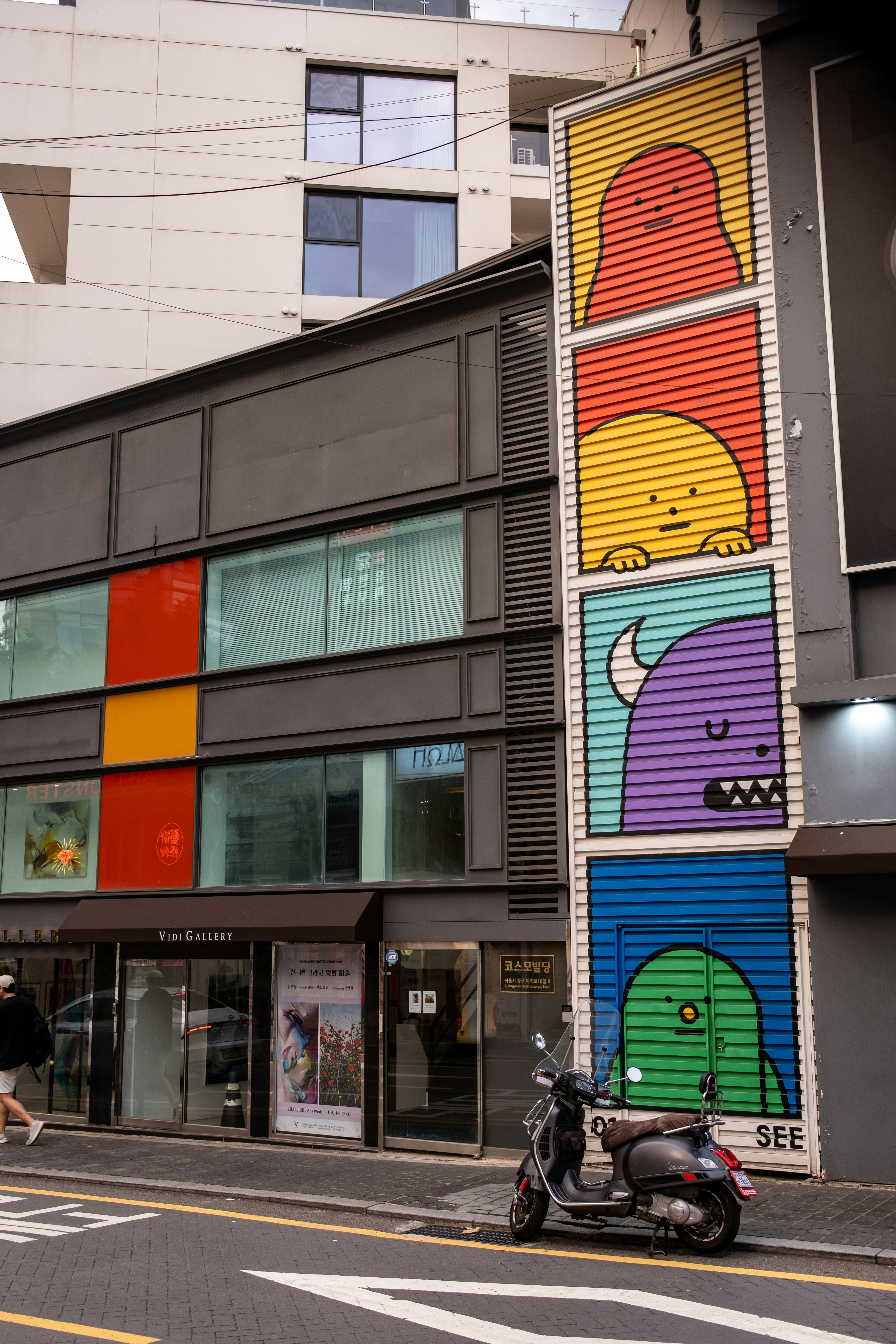 A scooter is parked in front of a colorful building