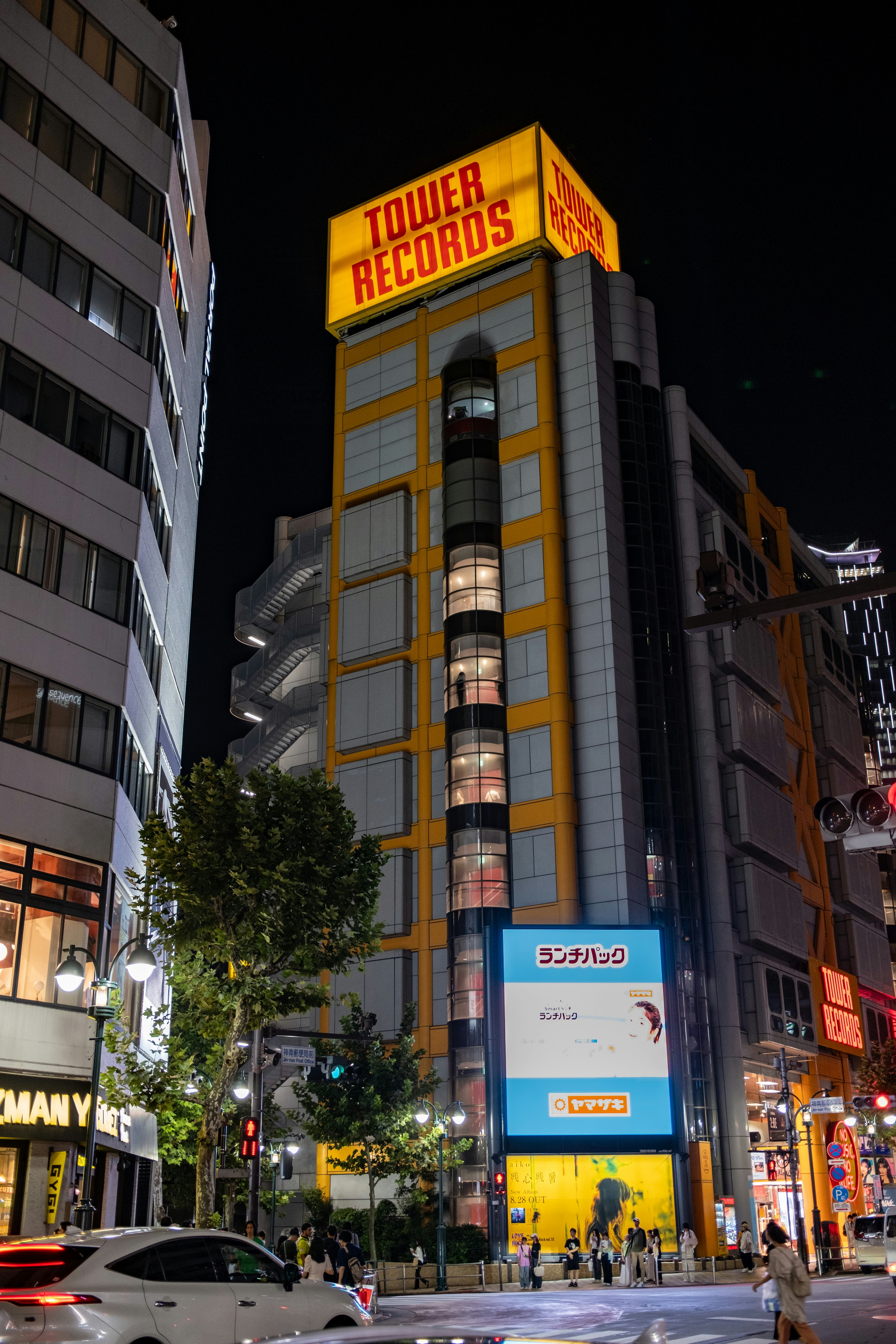 A busy city street at night with tall buildings