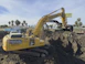A large yellow excavator sitting on top of a pile of dirt