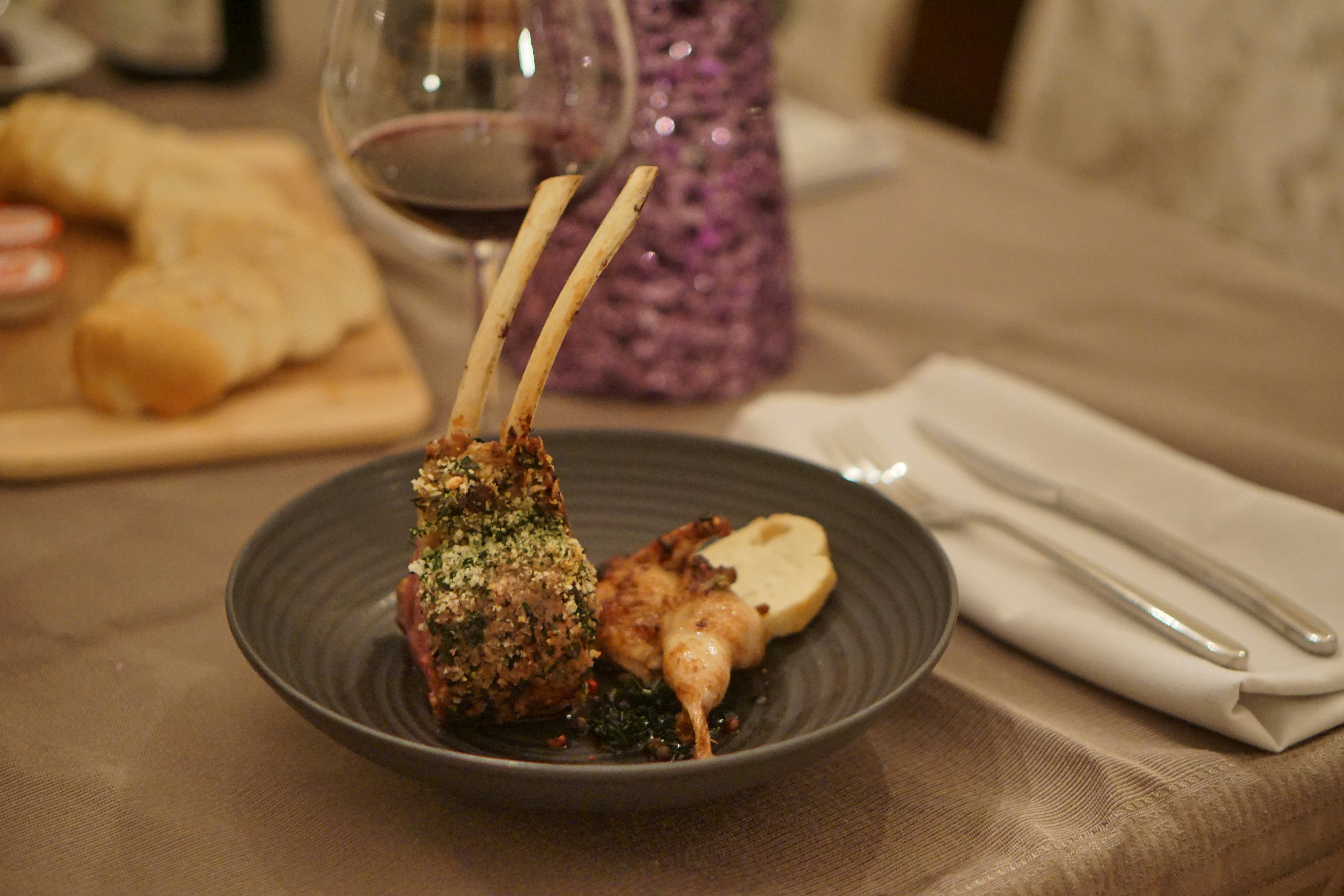A plate of food on a table with a glass of wine