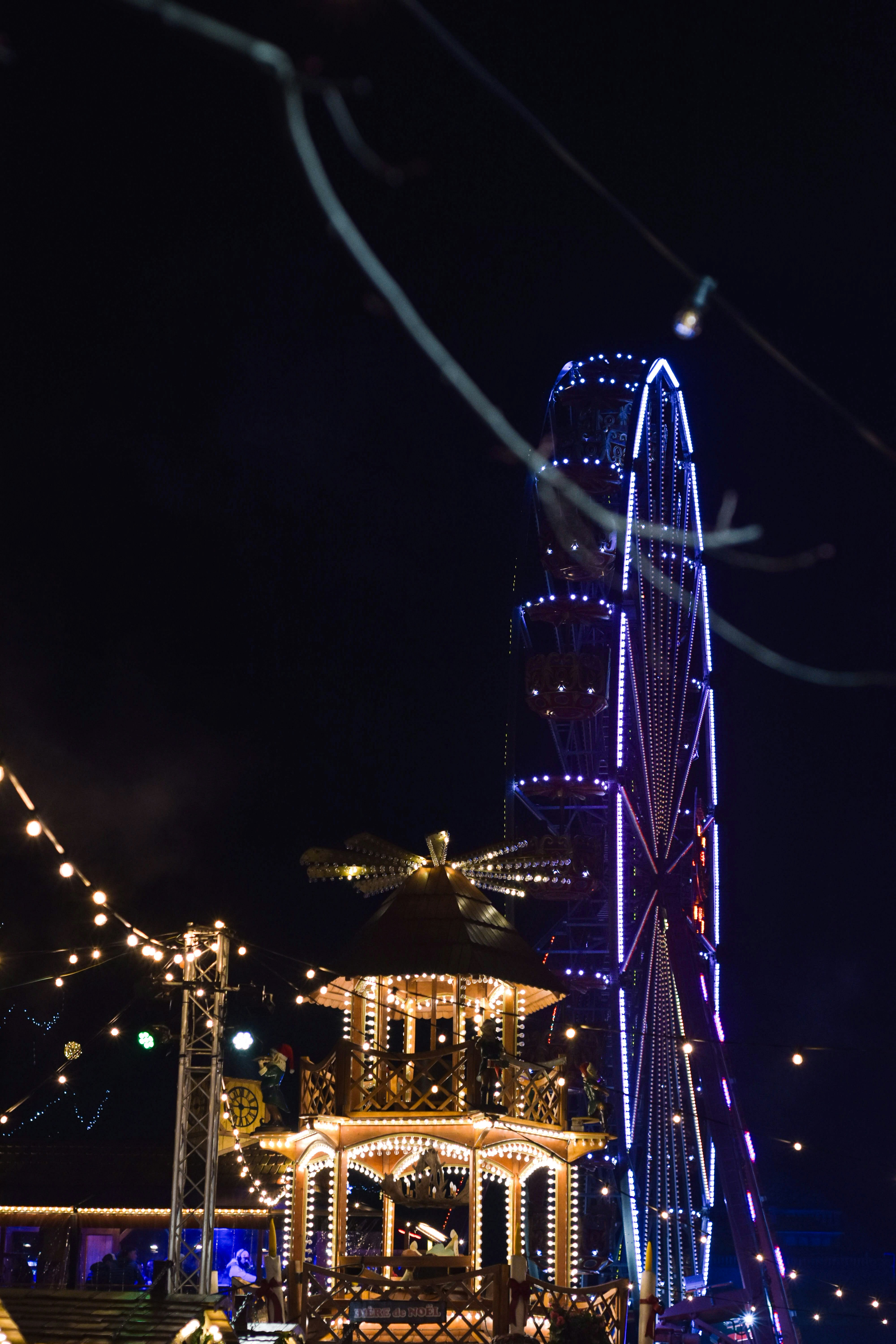 A ferris wheel is lit up at night