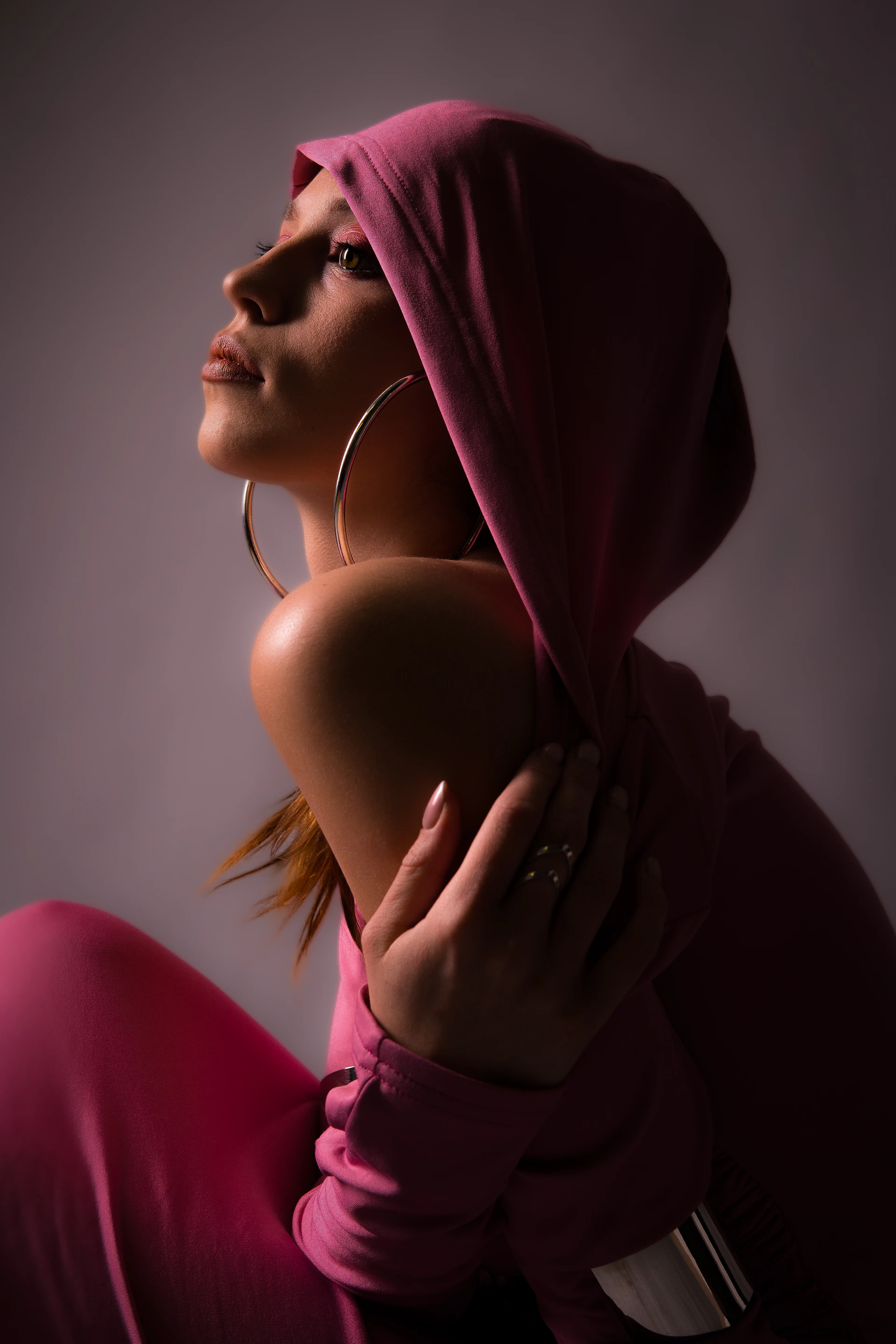 A woman in a pink outfit is posing for a picture