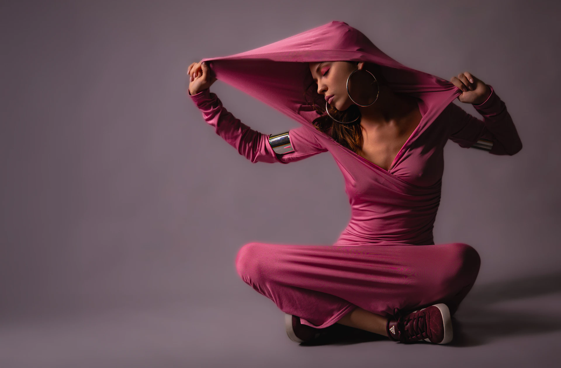 A woman in a pink dress sitting on the ground