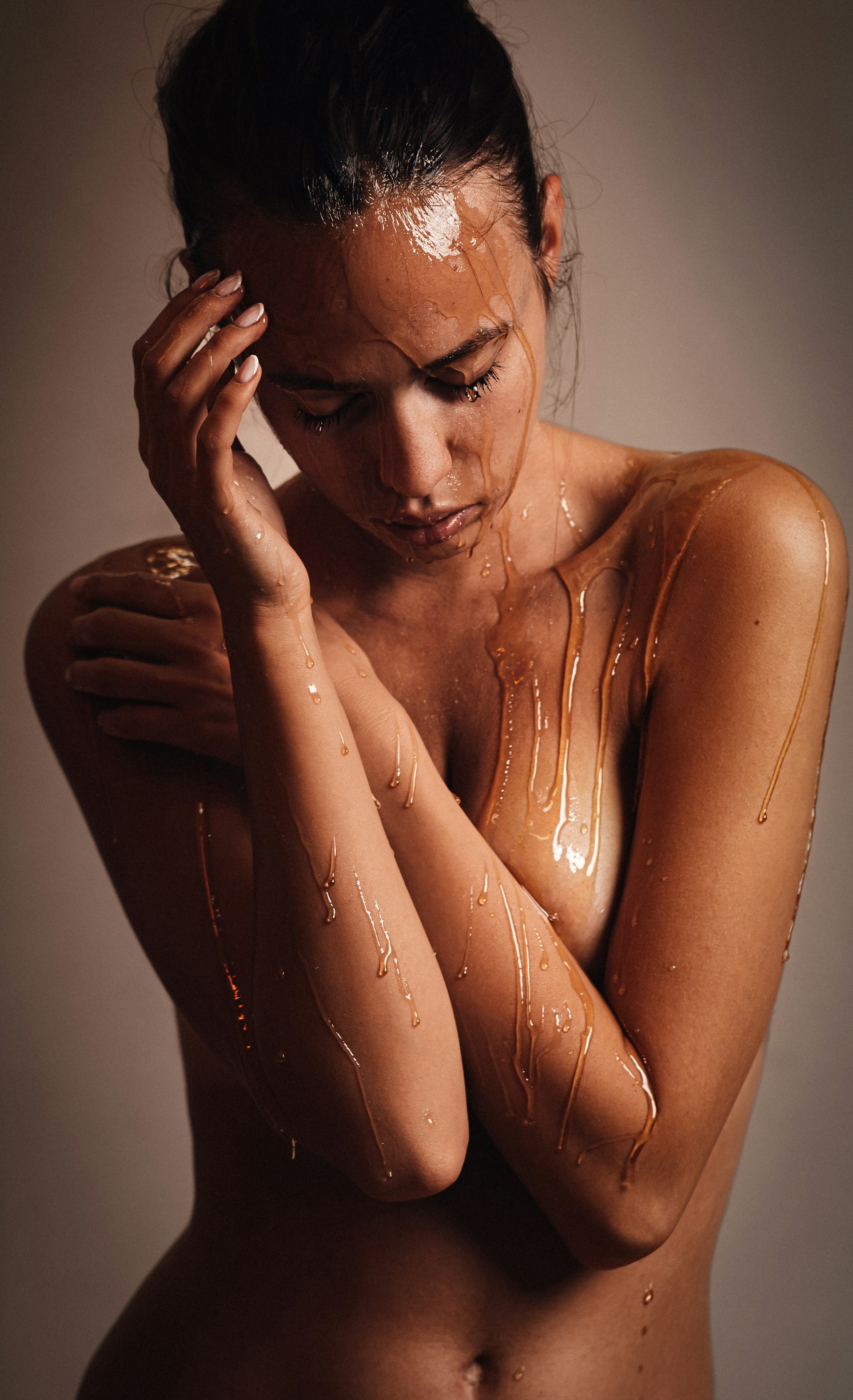 A naked woman covered in a shower of water