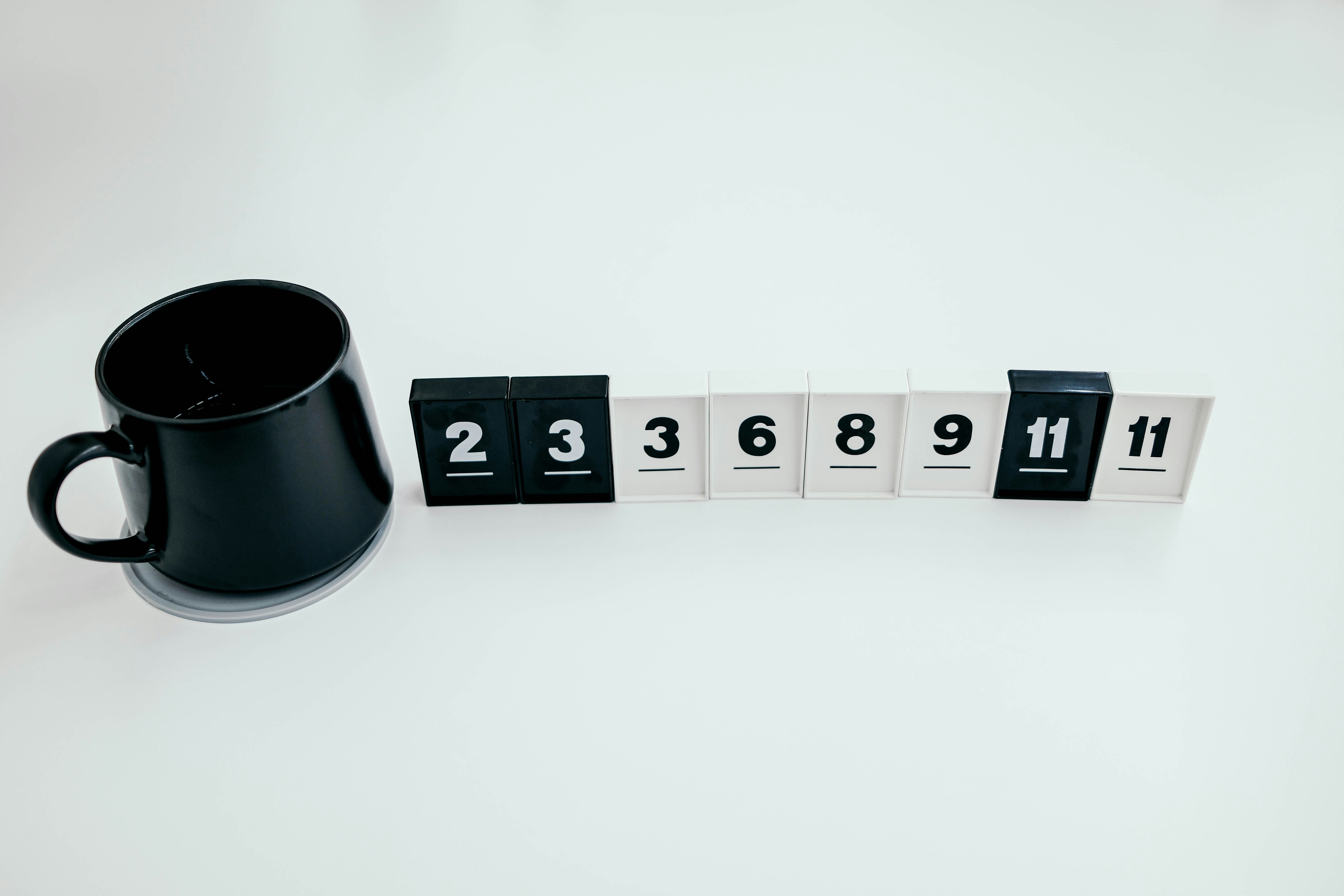 Black coffee mug next to numbers