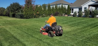 A man riding on the back of a lawn mower