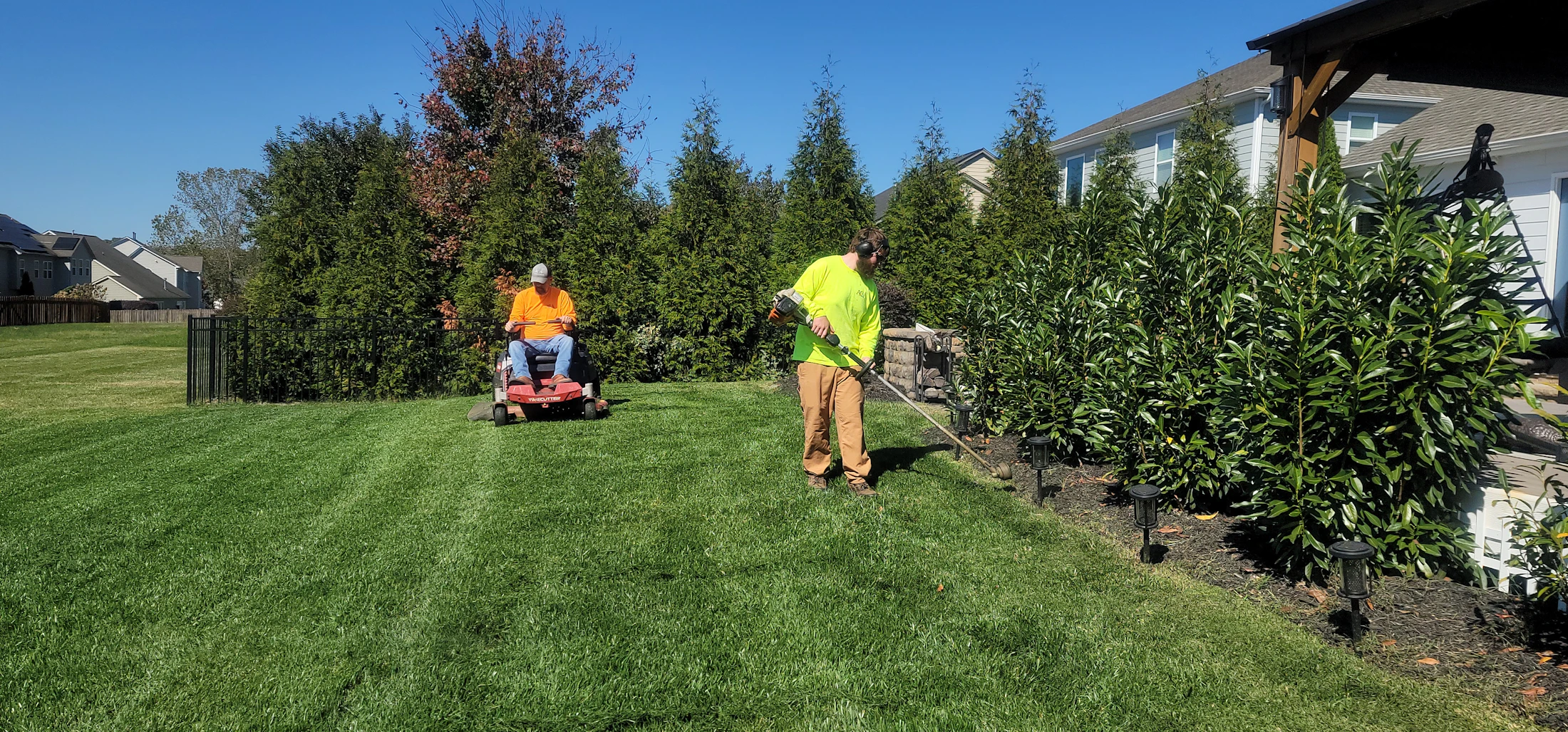 Professional mowing equipment cutting a residential lawn
