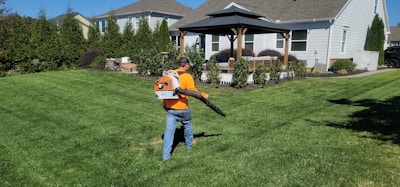 A man in an orange shirt holding a baseball bat