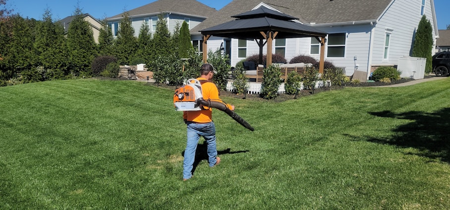 A man in an orange shirt holding a baseball bat