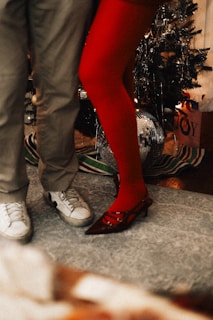 A man and a woman standing next to a christmas tree