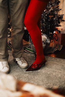A man and a woman standing next to a christmas tree