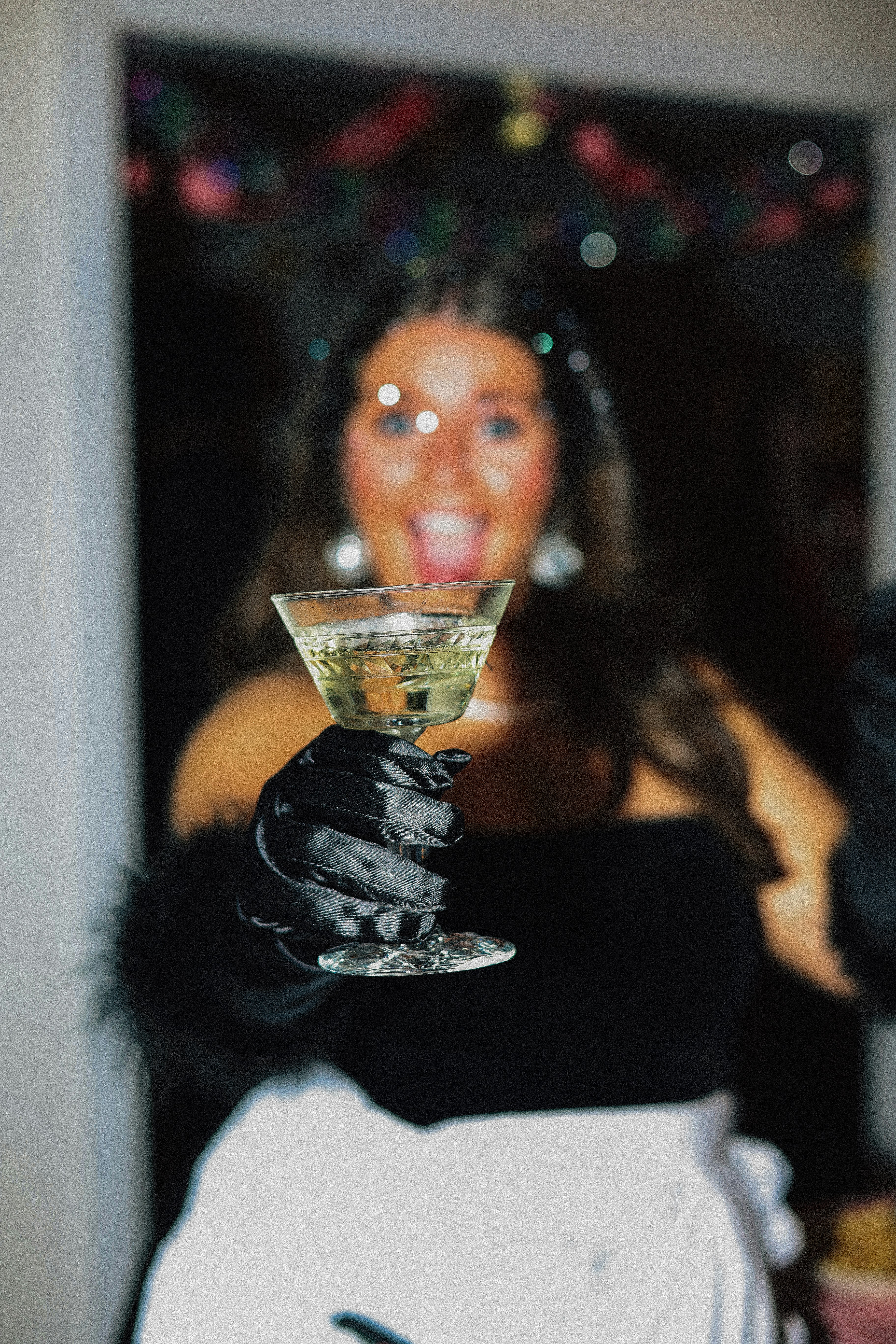 Woman enthusiastically raises a glass of champagne.