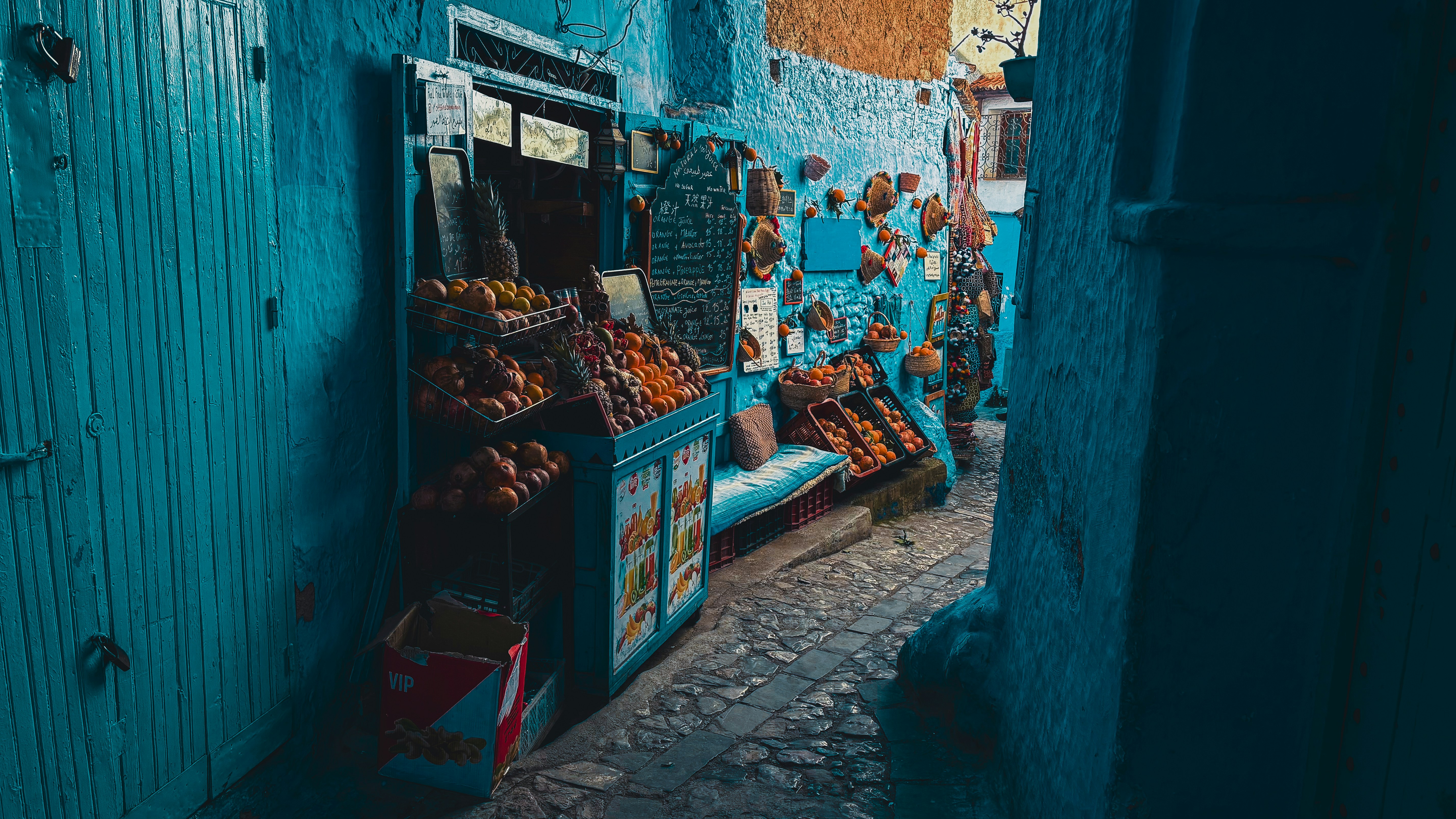 A narrow alley way with a blue painted wall