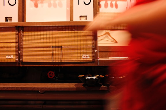 A woman in a red dress is standing in front of a store