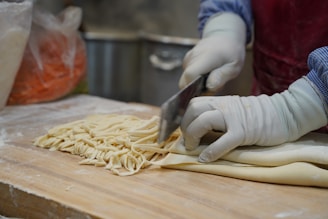 A person in a kitchen cutting up some food