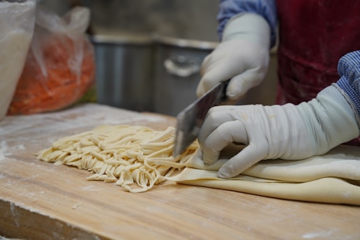 A person in a kitchen cutting up some food