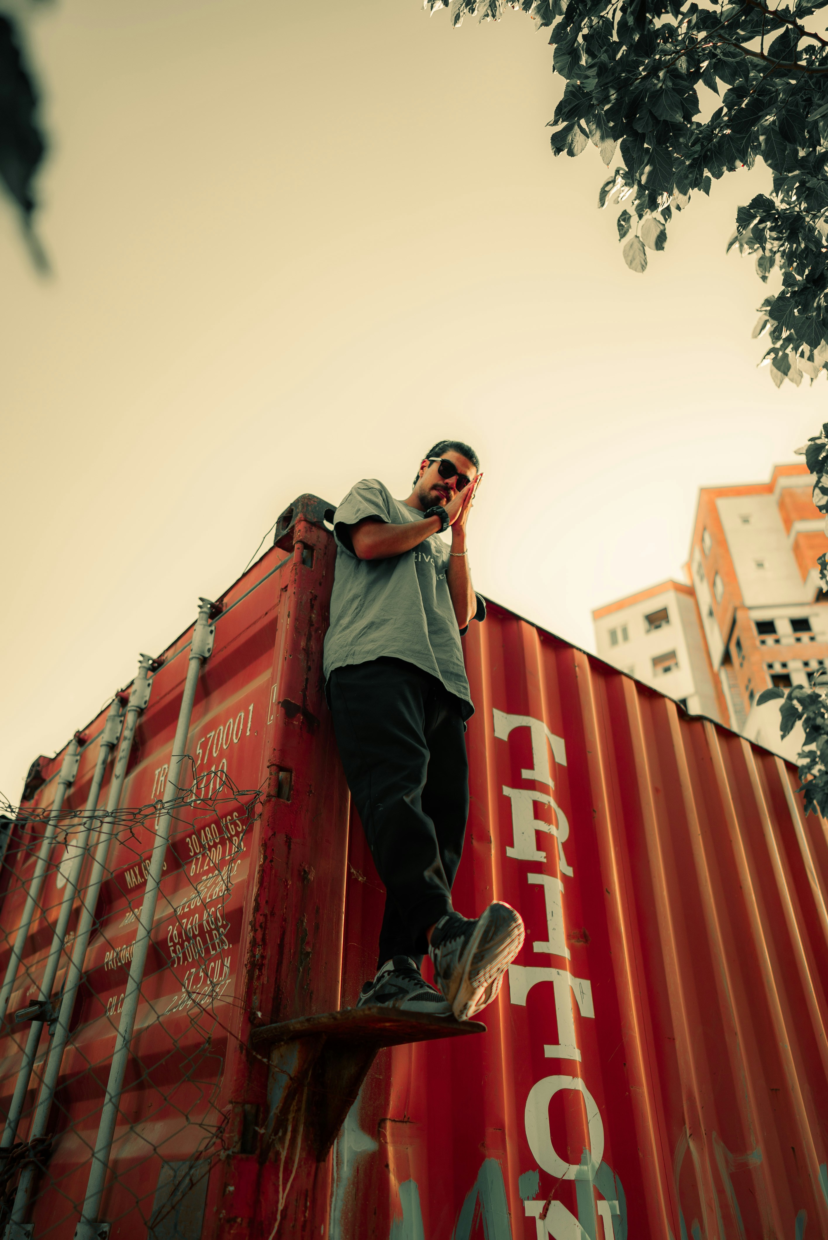 A man standing on top of a red container