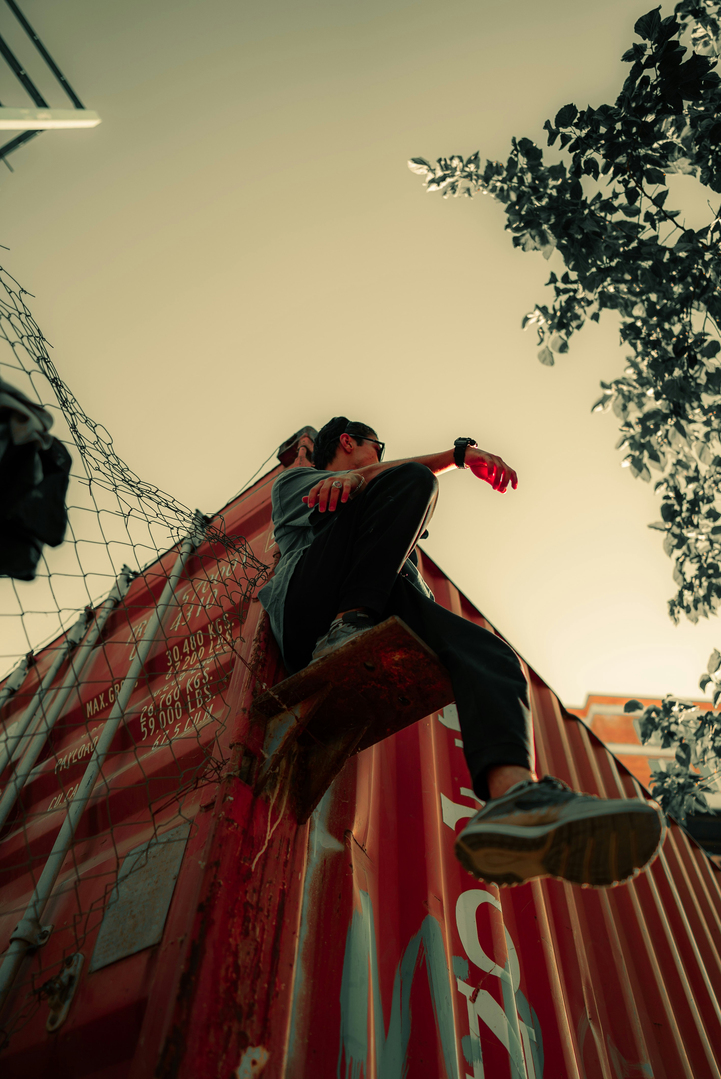 A man riding a skateboard down the side of a red wall