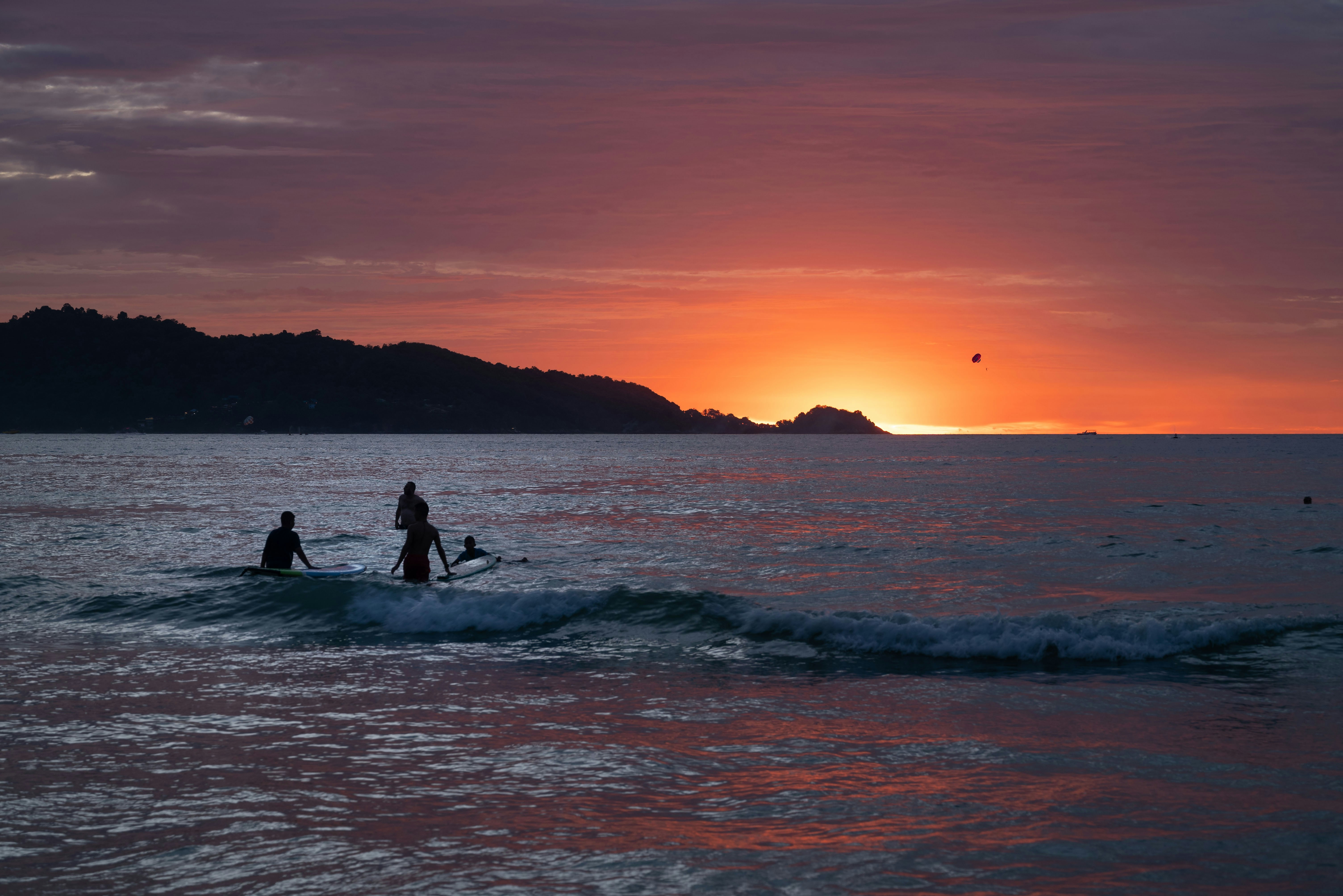 A couple of people riding a wave on top of a surfboard
