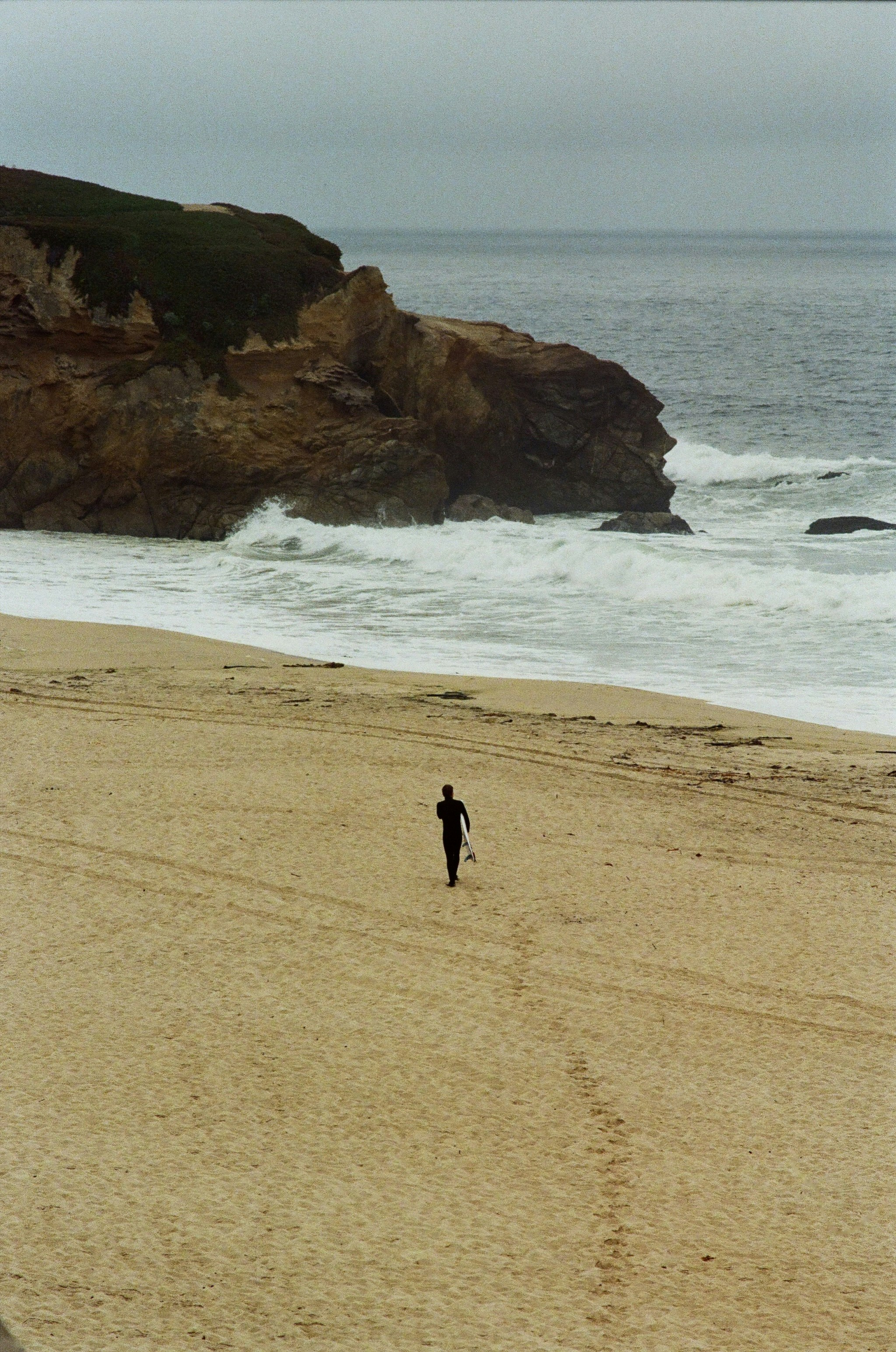 A person walking on a beach next to the ocean