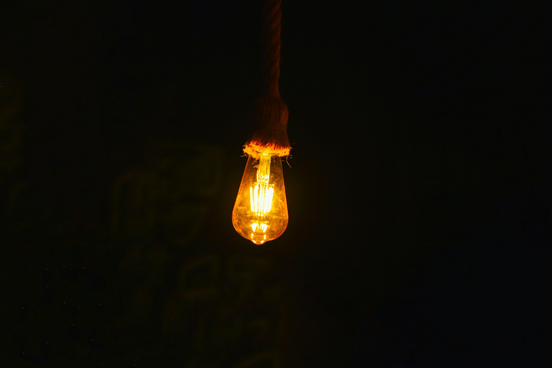 A light bulb hanging from a wire in the dark
