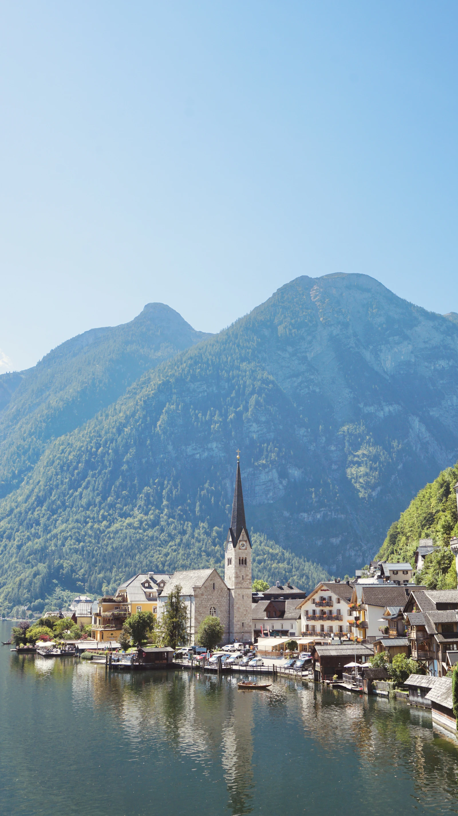Hallstatt village and church spire on an alpine lake, framed by forested mountains