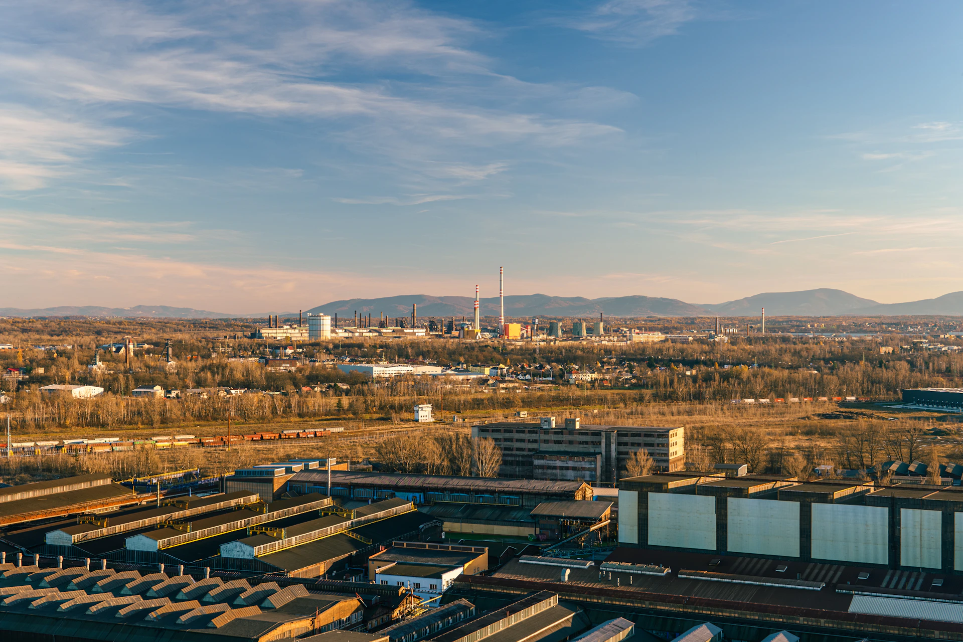 An aerial view of a train yard with mountains in the background