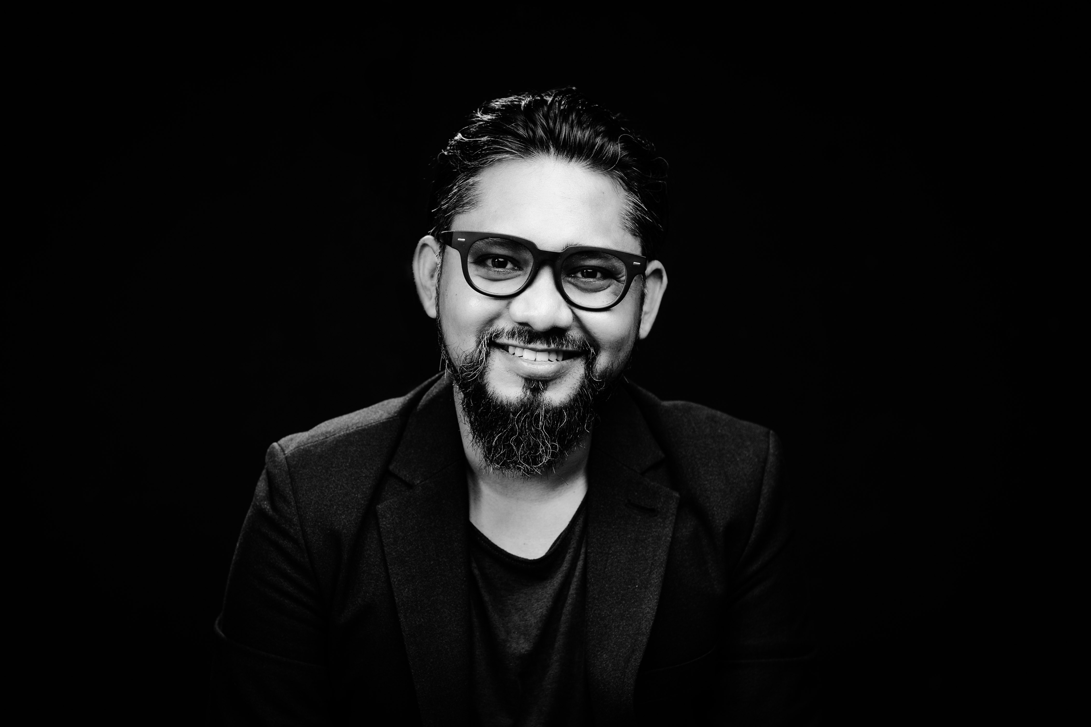 A black and white photo of a man with glasses