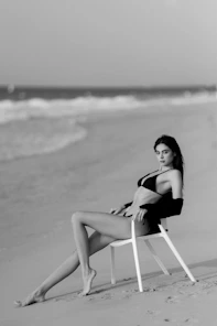 A woman sitting in a chair on the beach