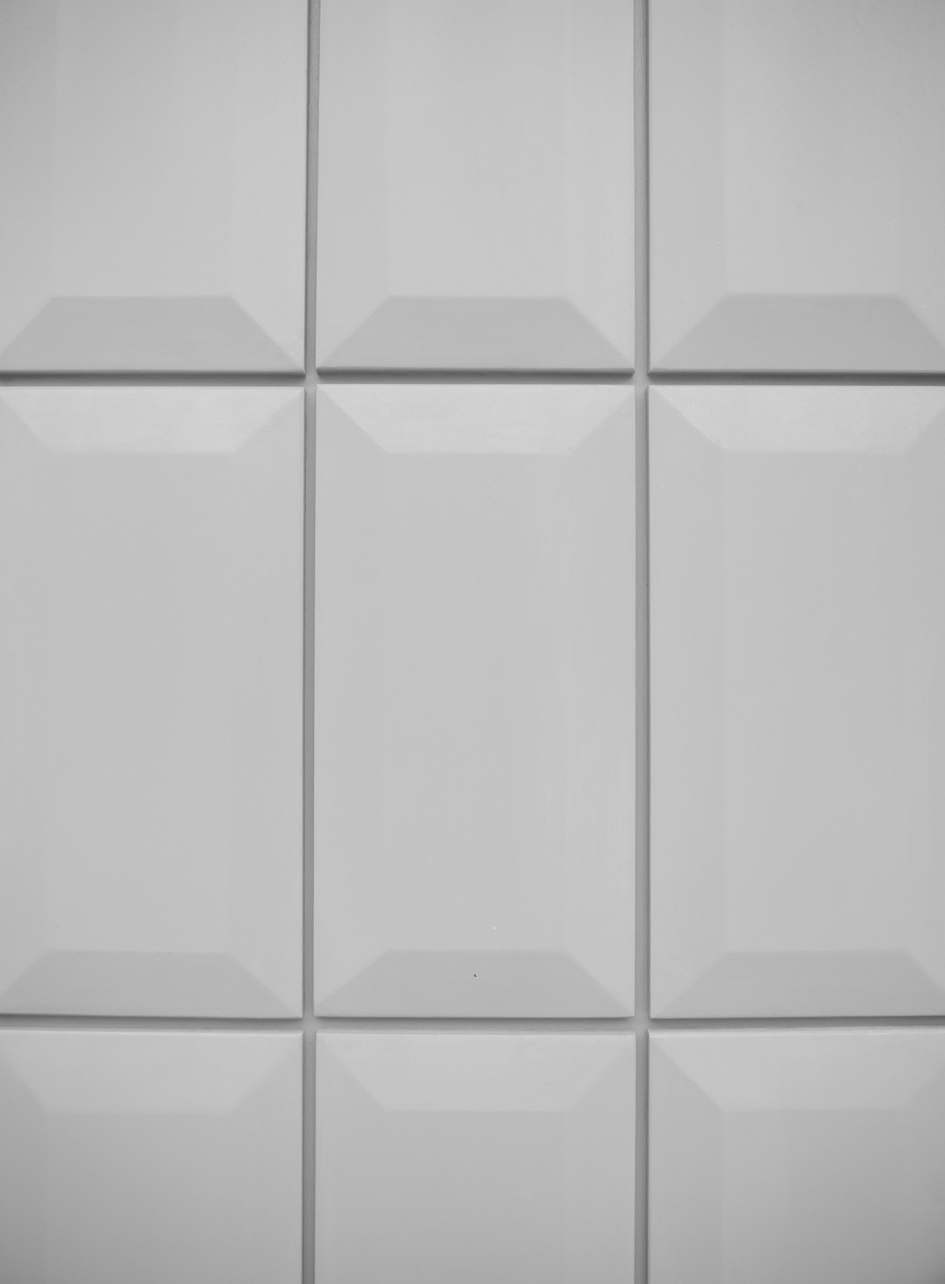 A white tiled wall with several square tiles