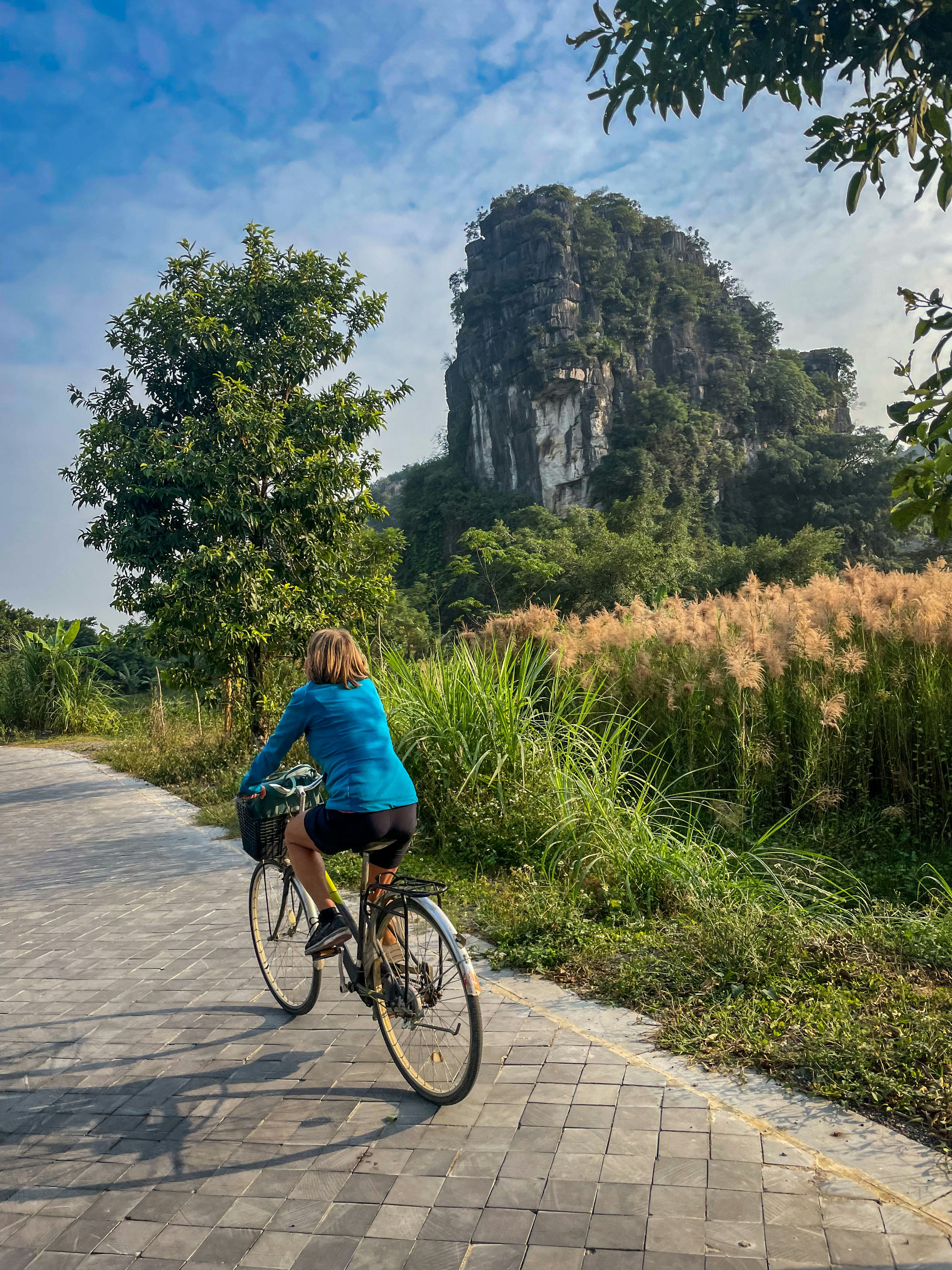 A woman riding a bike down a brick road