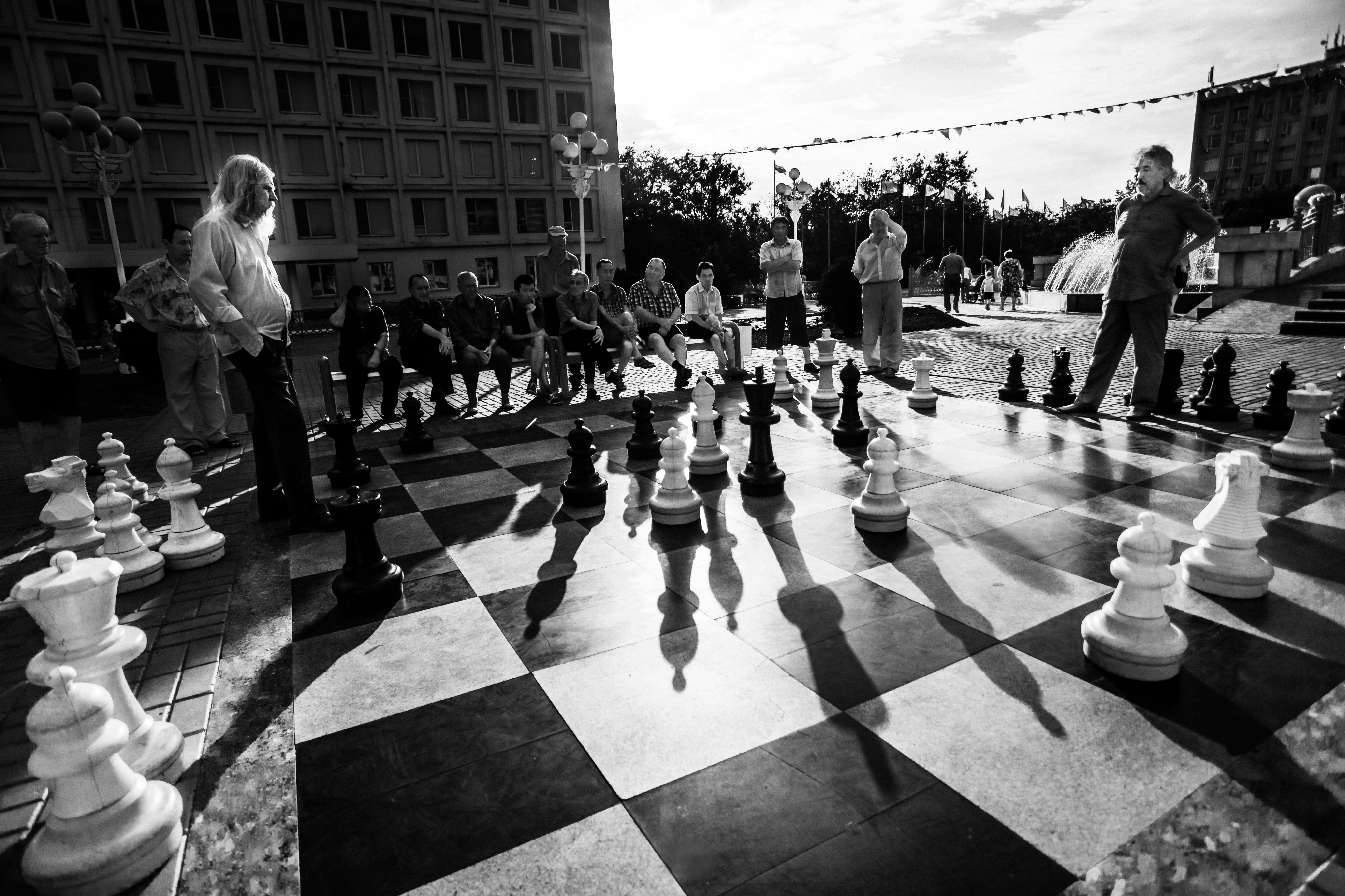A black and white photo of people playing chess