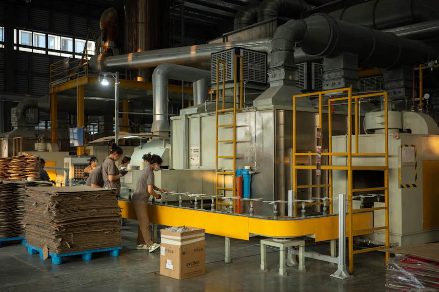 A corrugated box factory in India filled with production machinery and stacks of finished boxes ready for export