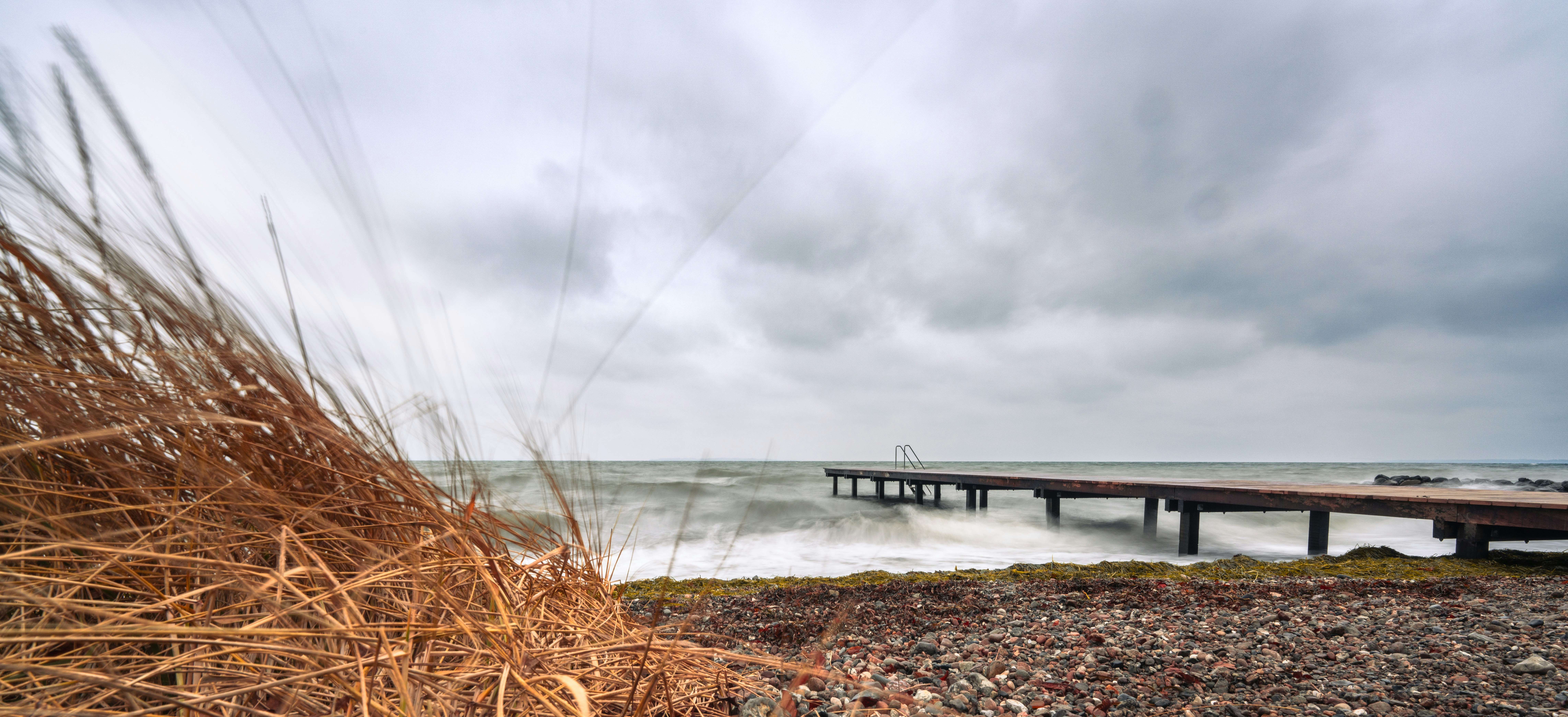 A beach with a pier in the distance