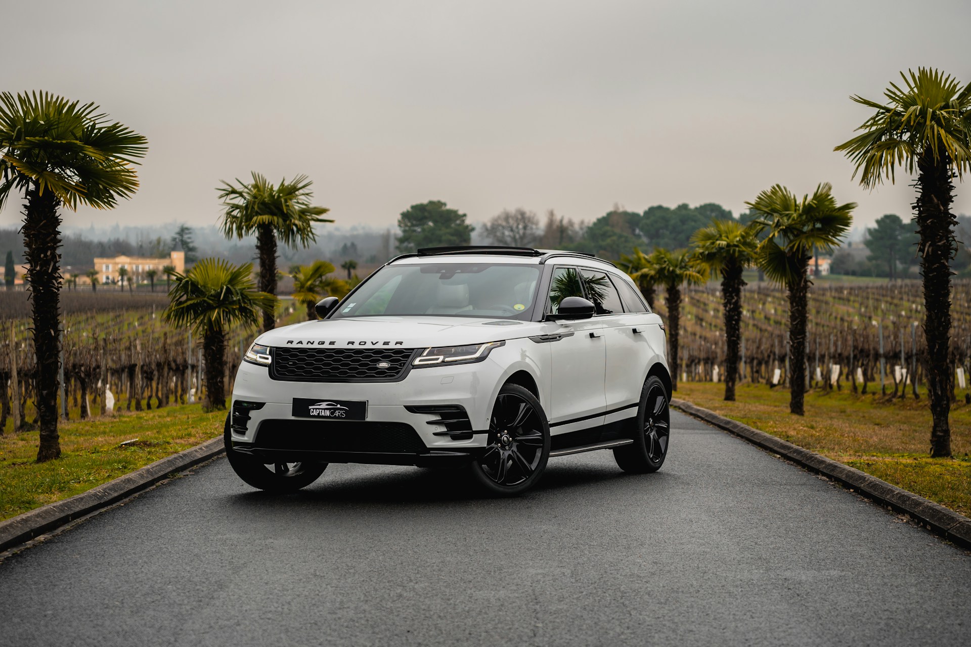 A white range rover parked on the side of a road