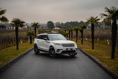 A white range rover velar driving down a road on premium car tyres