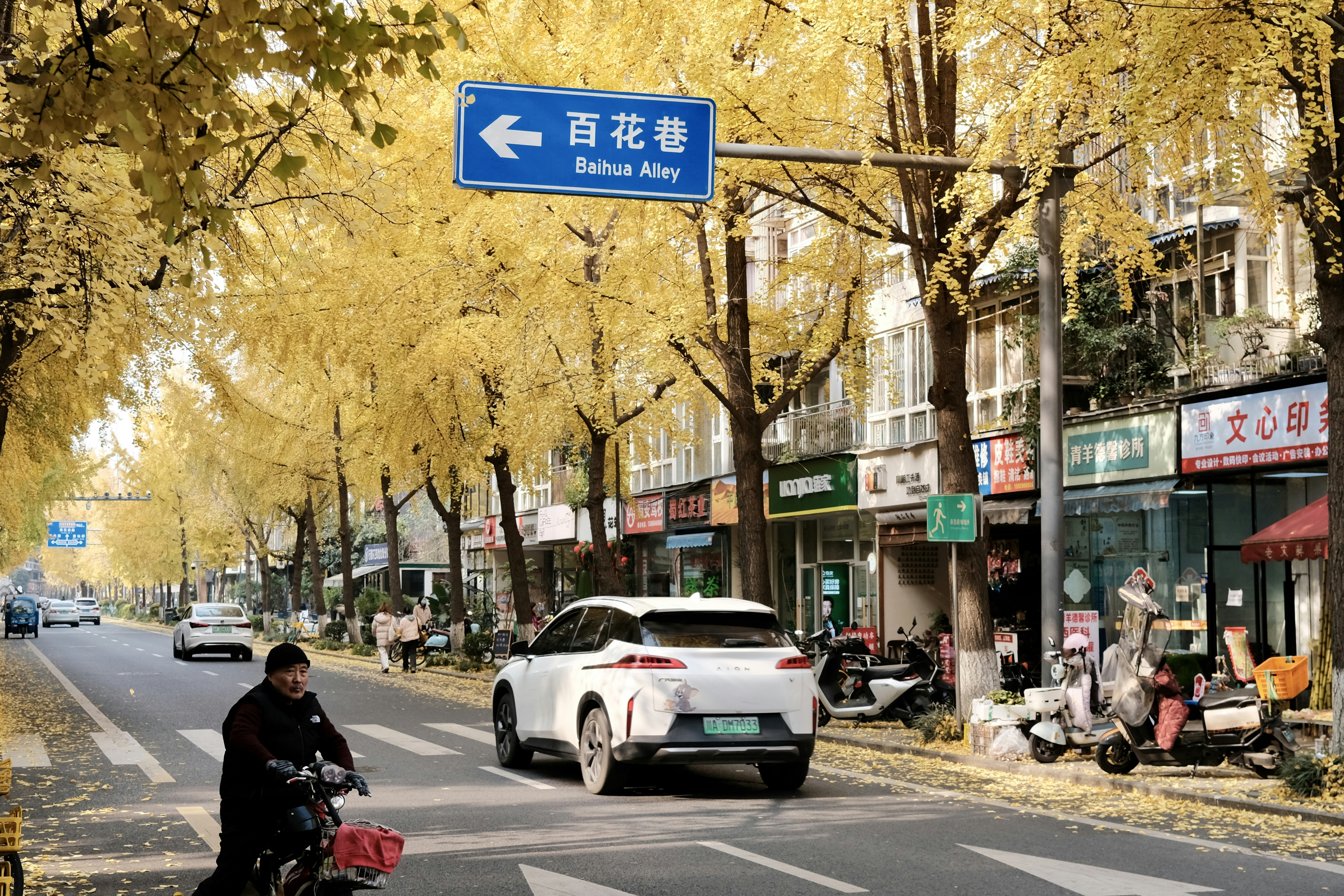 A man riding a bike down a street next to tall buildings
