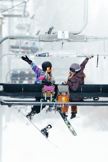 A couple of people riding a ski lift