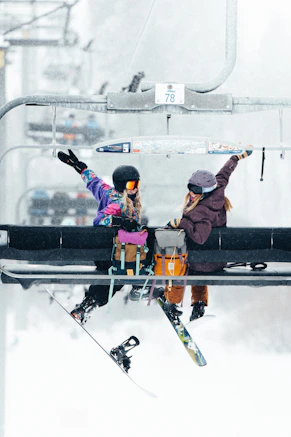 A couple of people riding a ski lift
