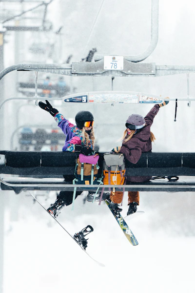 A couple of people riding a ski lift