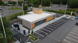An aerial view of a parking lot with a building in the background