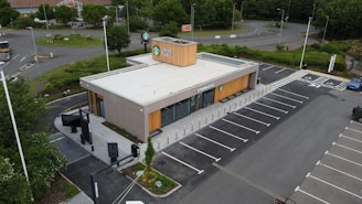 An aerial view of a parking lot with a building in the background