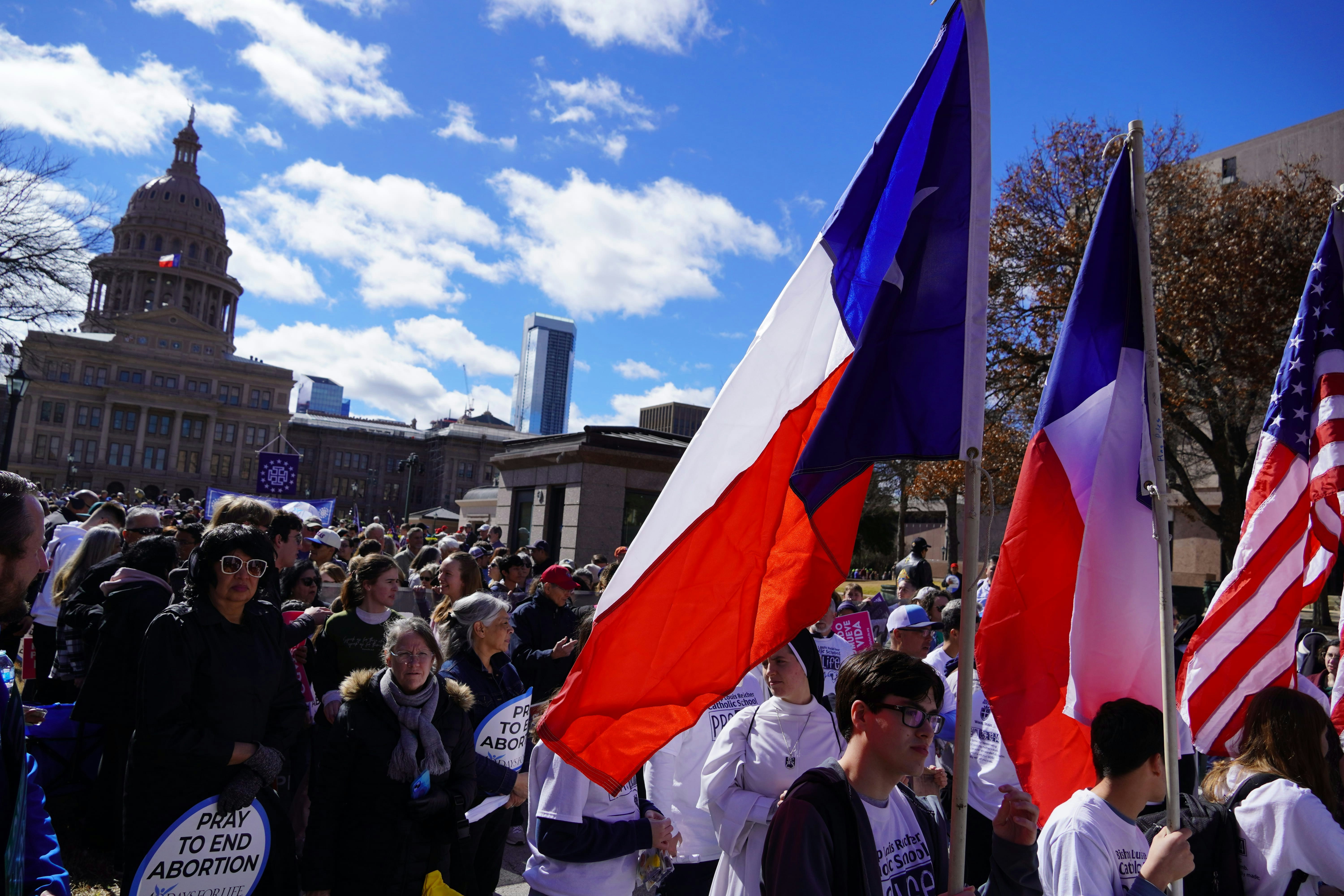 A group of people walking down a street holding flags