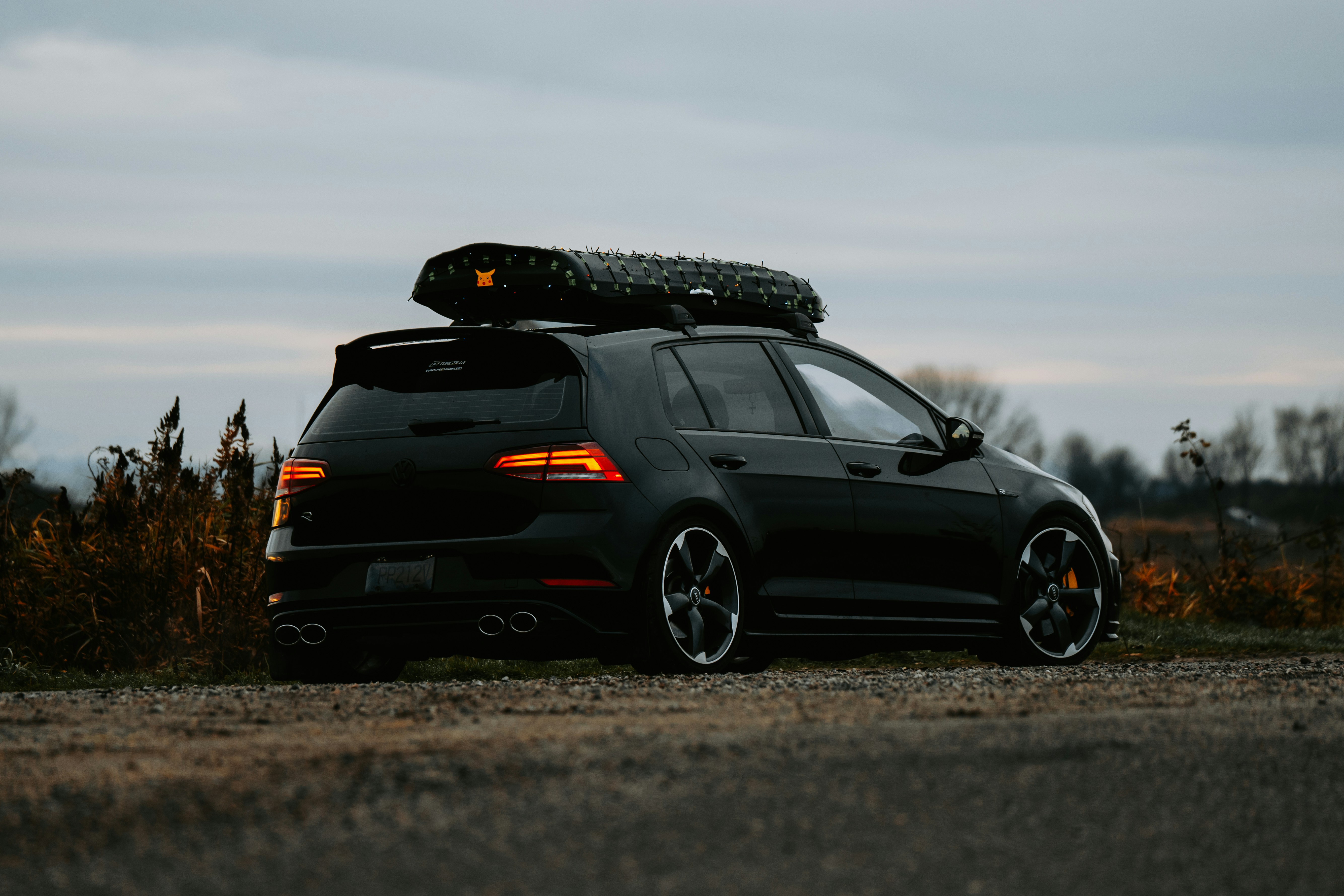 A black car with a surfboard on top of it