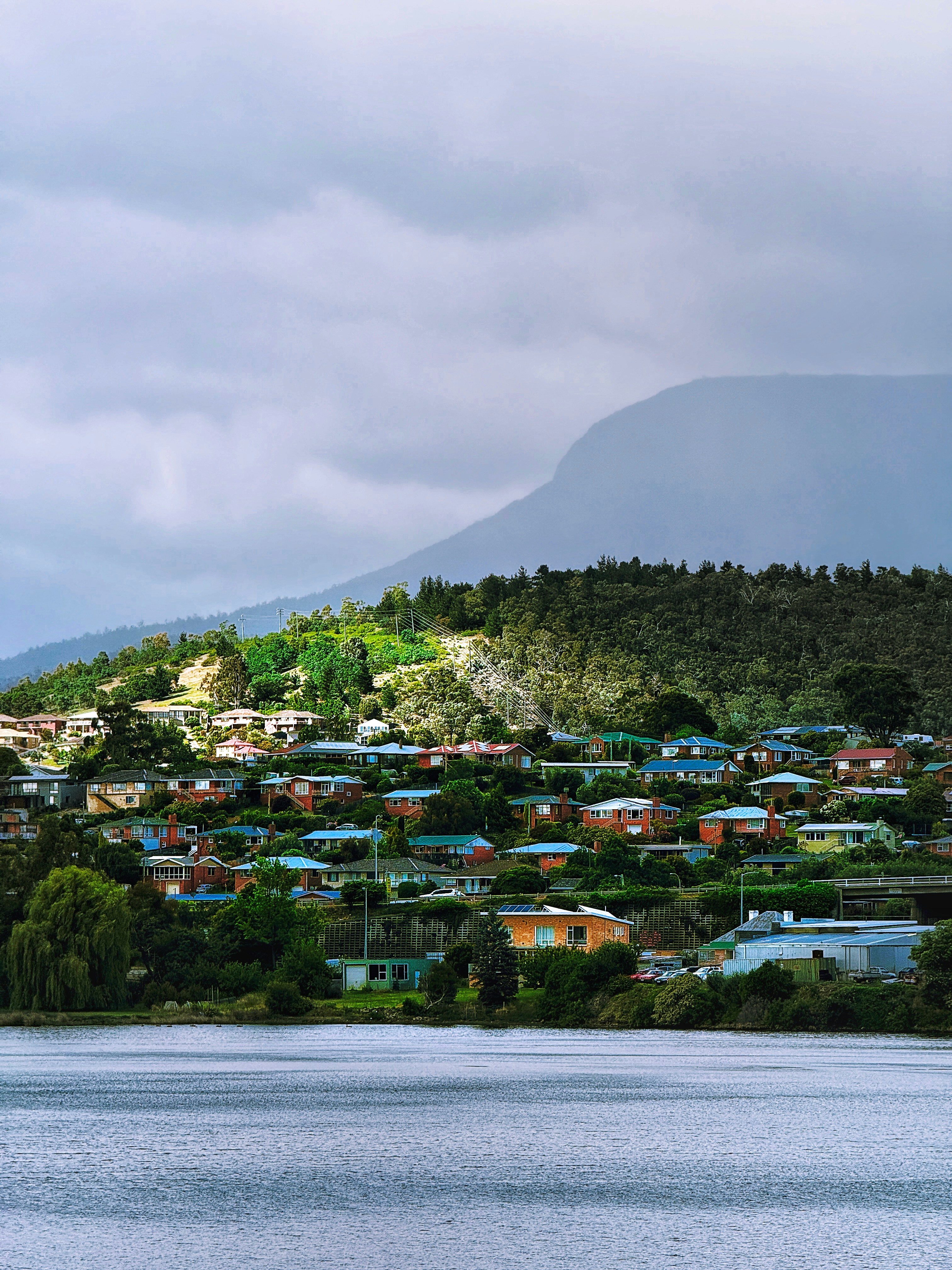 A lake with houses on it and a mountain in the background